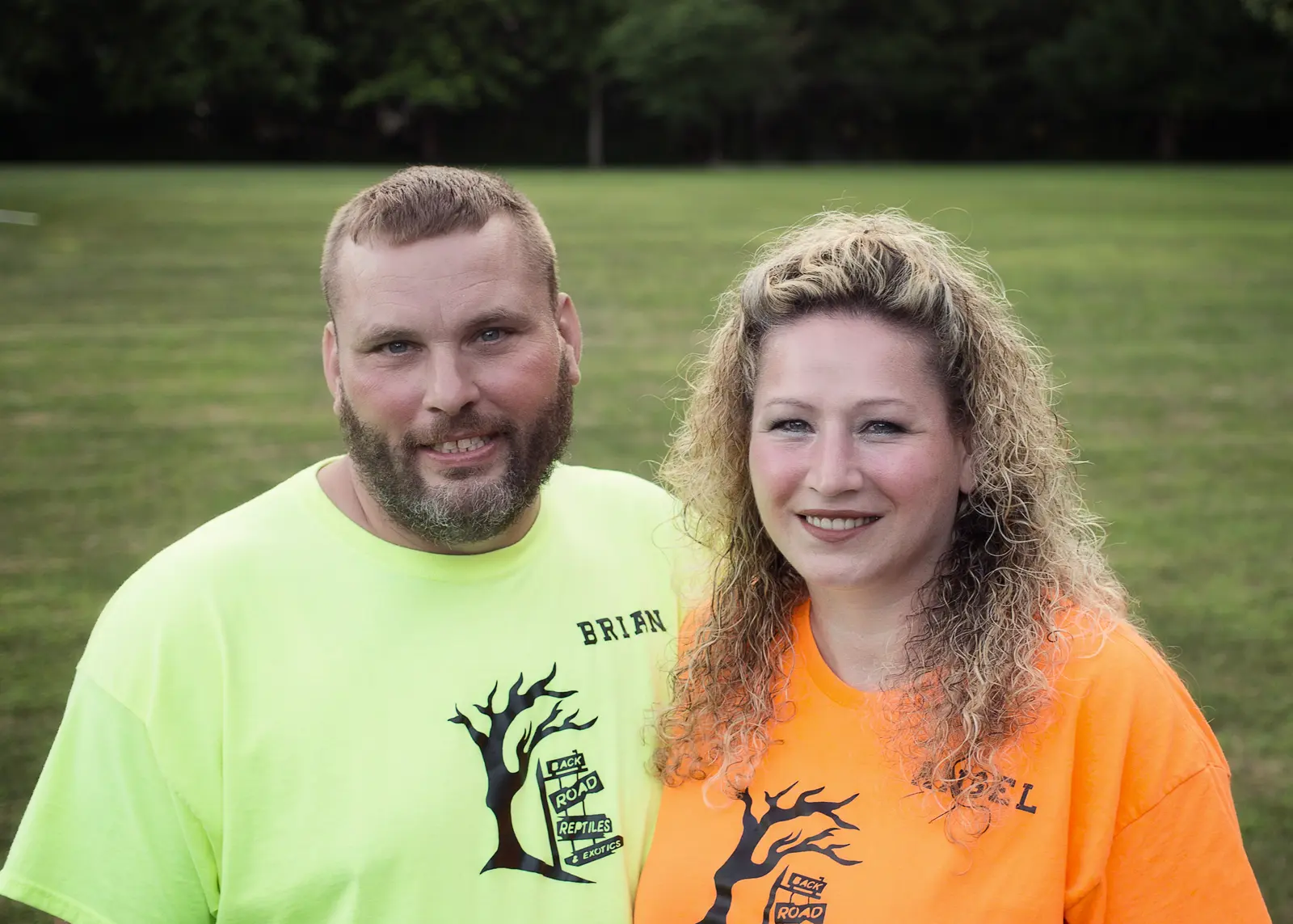 Brian and Angel, owners of Back Road Reptiles and Exotics LLC, wearing branded shirts outdoors